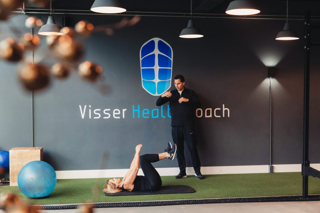 Personal trainer bespreekt kosten en trainingsplan met cliënt tijdens een kennismakingsgesprek